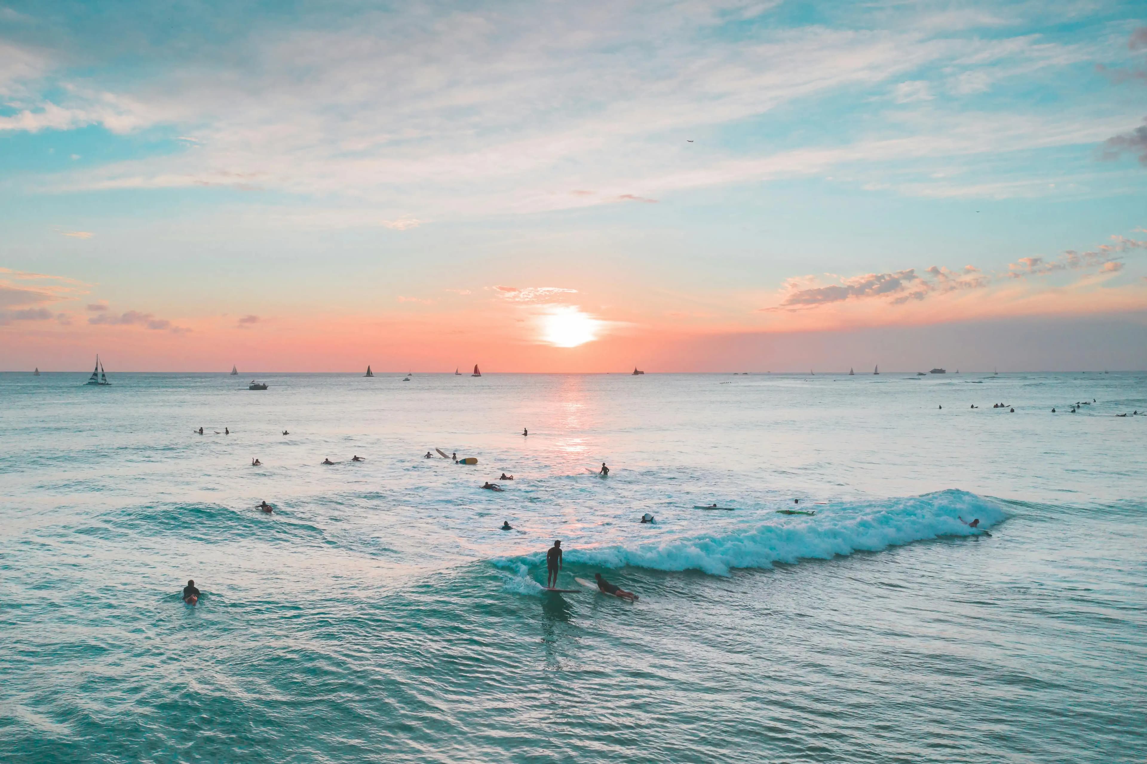 Sunset aerial photo of surfers in Ala Moana